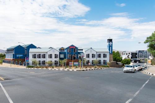 a street with a row of houses and a parking lot at Tenbergen Pension Hotel in Windhoek