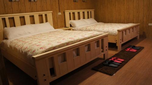two beds in a room with slippers on the floor at Monica Workshop in Renai