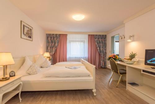 um quarto de hotel com uma cama e uma secretária em Gasthof Neuwirt em Ismaning