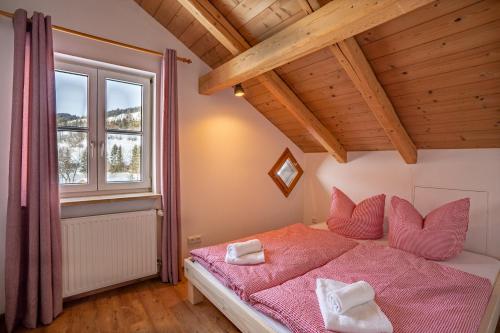 a bedroom with a pink bed and a window at Bergheimat in Bad Hindelang