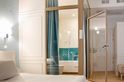 a bedroom with a glass door leading to a bathroom at Hotel Villa Baltica in Sopot