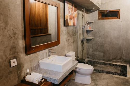 a bathroom with a sink and a toilet at Japa Guesthouse in Canggu