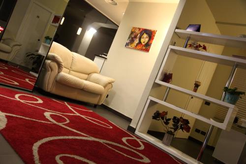 a living room with a couch and a red rug at Hotel Le Ceramiche in Montalto Uffugo