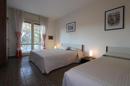 a hotel room with two beds and a window at Villa Stefano in Bibione