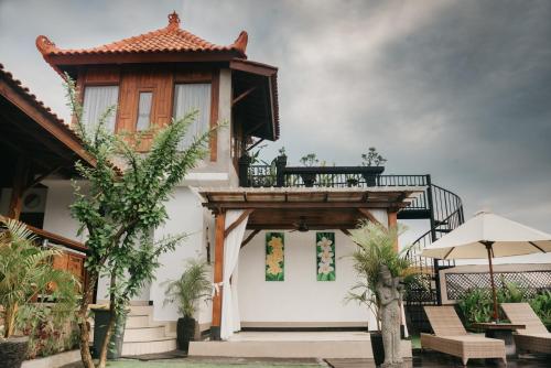 a building with a balcony with a table and chairs at Japa Guesthouse in Canggu