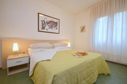 una camera da letto con un letto grande con una coperta verde di Appartamenti Angela e Pordenone a Bibione
