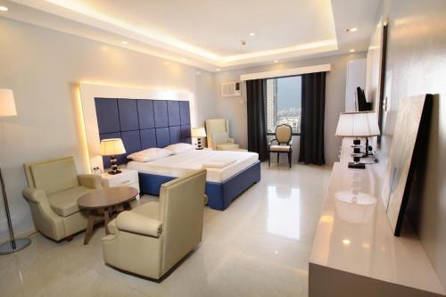 1 dormitorio con 1 cama, mesa y sillas en Malate Bayview Mansion city view en Manila