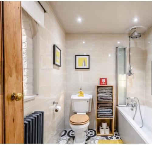 a bathroom with a toilet and a tub and a sink at Chestnut Lodge in East Dereham