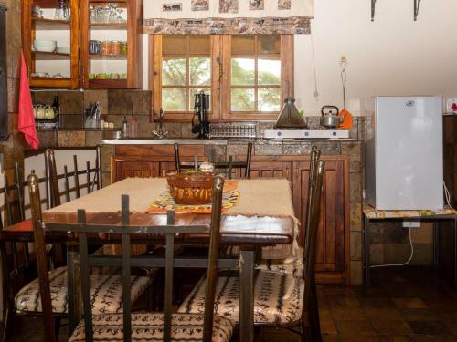 a kitchen with a table and a refrigerator at Africa Awaits Lodge & Safaris in Gobabis