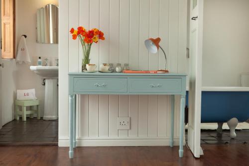 a blue table with a vase of flowers on it at La Grenadine in Cape Town