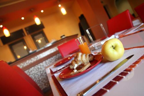 a plate of food and an apple on a table at Hotel Le Ceramiche in Montalto Uffugo