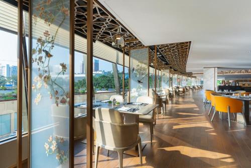 a dining room with tables and chairs and windows at China Hotel Guangzhou - Subway direct to Pazhou Exhibition Center, Free shuttle during Canton Fair & Exhibitor registration Counter in Guangzhou