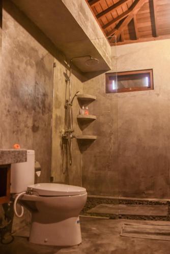 a bathroom with a toilet in a room at Japa Guesthouse in Canggu