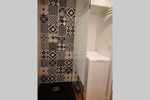 a bathroom with a black and white tile wall at L'horizon 2 - bord de mer in Ploemeur