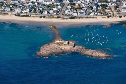 an island in the ocean with a group of birds on it at L'horizon 2 - bord de mer in Ploemeur