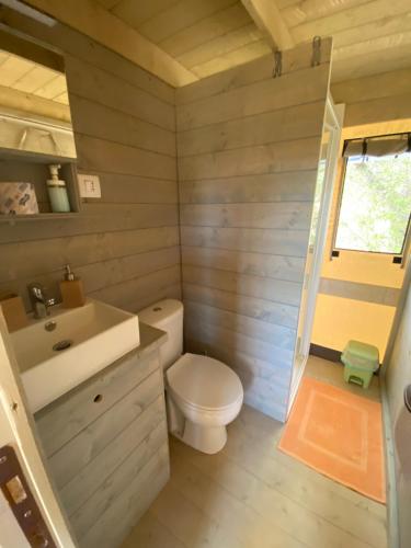 a bathroom with a white toilet and a sink at Ciriga Sicily Glamping in Santa Maria Del Focallo