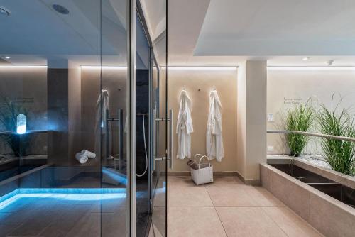 La salle de bains est pourvue d'une douche et d'une piscine. dans l'établissement Baumgartner's Blumenhotel, à Schenna