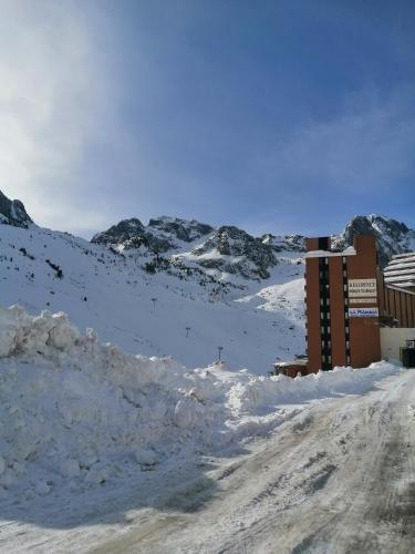 une route couverte de neige avec des montagnes en arrière-plan dans l'établissement Studio 1 pièces avec balcon pieds des pistes la mongie tourmalet, à Bagnères-de-Bigorre