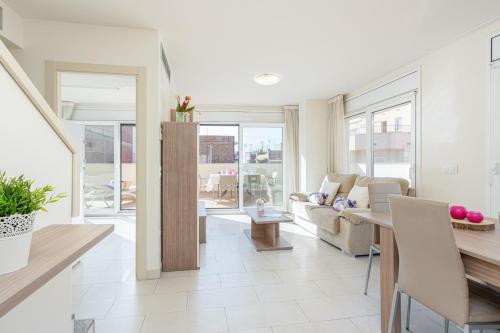 uma sala de estar com um sofá e uma mesa em Apart-rent Apartment Francesc Macia Penthouse 2000 em Roses