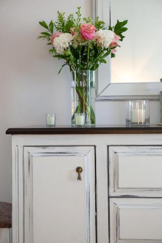 a vase of flowers sitting on top of a cabinet at Sunrise Apartment Santorini in Emporio