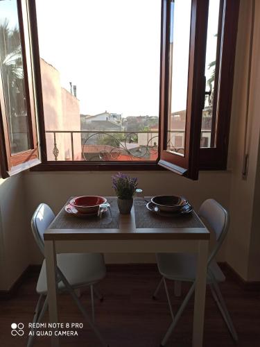 a table and chairs in a room with a window at Piazza San Giorgio in Dolianova
