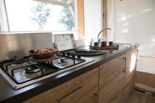 a kitchen with a stove with a bowl of food on it at Ciriga Sicily Glamping Resort in Santa Maria Del Focallo