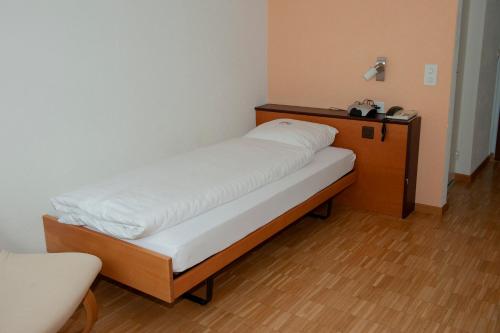 a bed in a room with white sheets on it at Hotel Sporting in Marbach