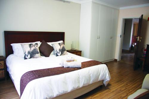 a bedroom with a bed with two dogs on the pillows at African BnB - The Boutique Experience in Benoni