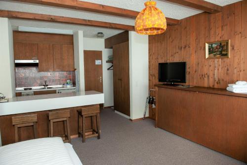 a room with a kitchen with a bar and a tv at Hotel Sporting in Marbach