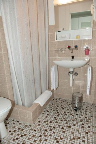 a bathroom with a sink and a shower and a toilet at Hotel Sporting in Marbach
