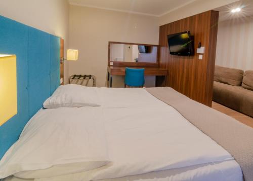 duże białe łóżko w pokoju z kanapą w obiekcie Holiday Home Aparthotel w mieście Międzyzdroje