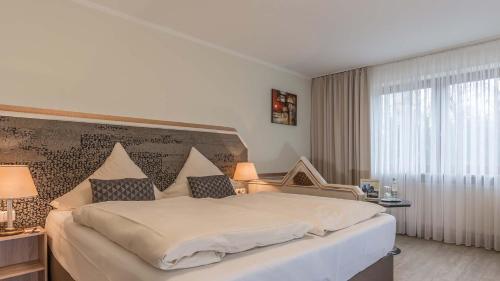 Ein Bett oder Betten in einem Zimmer der Unterkunft Hotel am Schlosspark