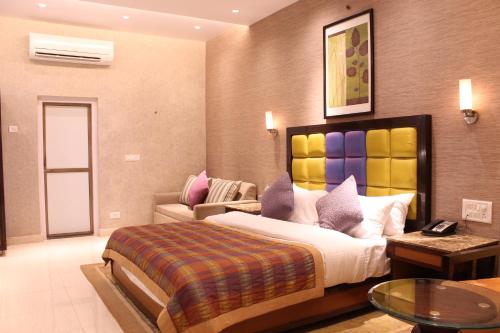 - une chambre avec un grand lit et un canapé dans l'établissement The Byke Brightland Adventure Park & Resort, à Mumbai