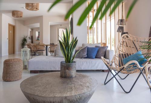 a living room with a couch and a table with a plant at 180 South Seaside Hotel in Thermisia