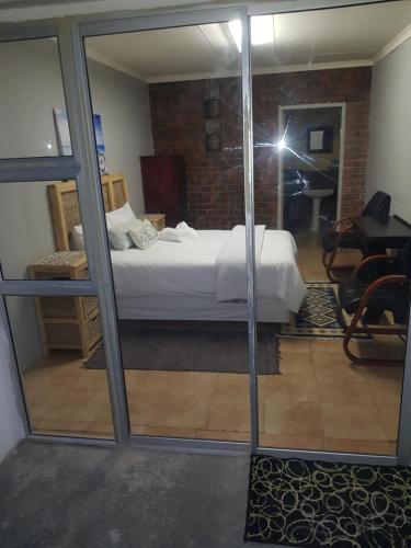 a view of a bedroom with a bed through a window at AGT Guesthouse in Vryheid