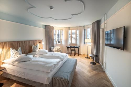 Best Western Plus Hotel Bern في برن: غرفة نوم بسرير وتلفزيون بشاشة مسطحة