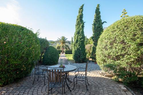 a patio with chairs and a table in a garden at 180 South Seaside Hotel in Thermisia