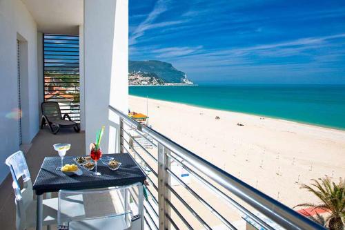 een balkon met een tafel en uitzicht op het strand bij Il Conero Mare in Numana