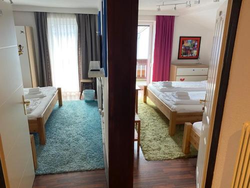 a bedroom with two beds and a room with two beds at Hotel Wildschütz Basic in Altmünster
