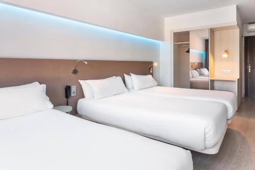 two white beds in a hotel room at B&B HOTEL Donostia Aeropuerto in Oiartzun
