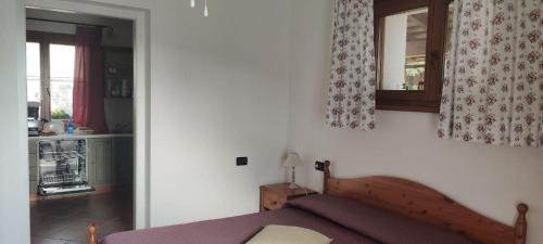 1 dormitorio con 1 cama y cocina con ventana en Casa Luis, en Cividale del Friuli