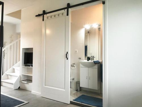 a sliding door leading to a bathroom with a sink at Vakantiehuis Sonnewende in Veere