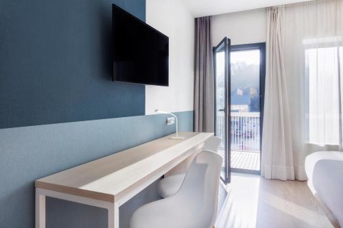 a room with a desk and a tv on a wall at B&B HOTEL Donostia Aeropuerto in Oiartzun