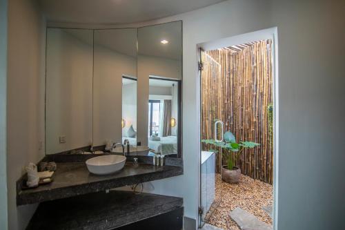 a bathroom with a sink and a large mirror at Ren Resort in Sihanoukville