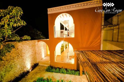 an orange building with two arches and a balcony at Casa San Roque Valladolid in Valladolid
