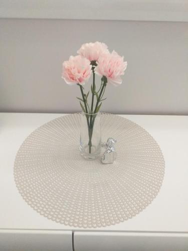 a vase with pink flowers sitting on a table at Elizabeth Apartman 2 in Hévíz