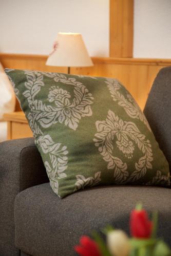 a green pillow sitting on a couch with a lamp at Hotel Menning ***S in Oberstdorf