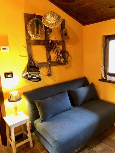 a living room with a blue couch and a table at Cascina La Maddalena Bed & Wine in Rocca Grimalda