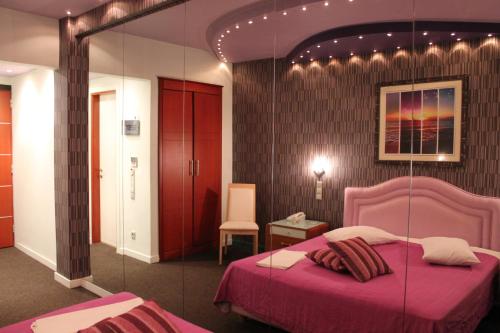 a bedroom with a pink bed and a mirror at Carol Hotel in Piraeus
