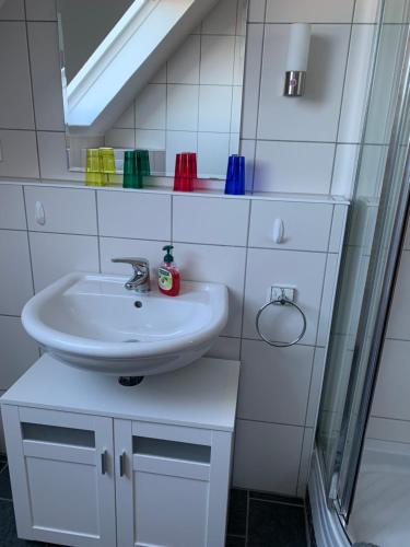 y baño con lavabo y espejo. en Ferienwohnung_25, en Uphusum